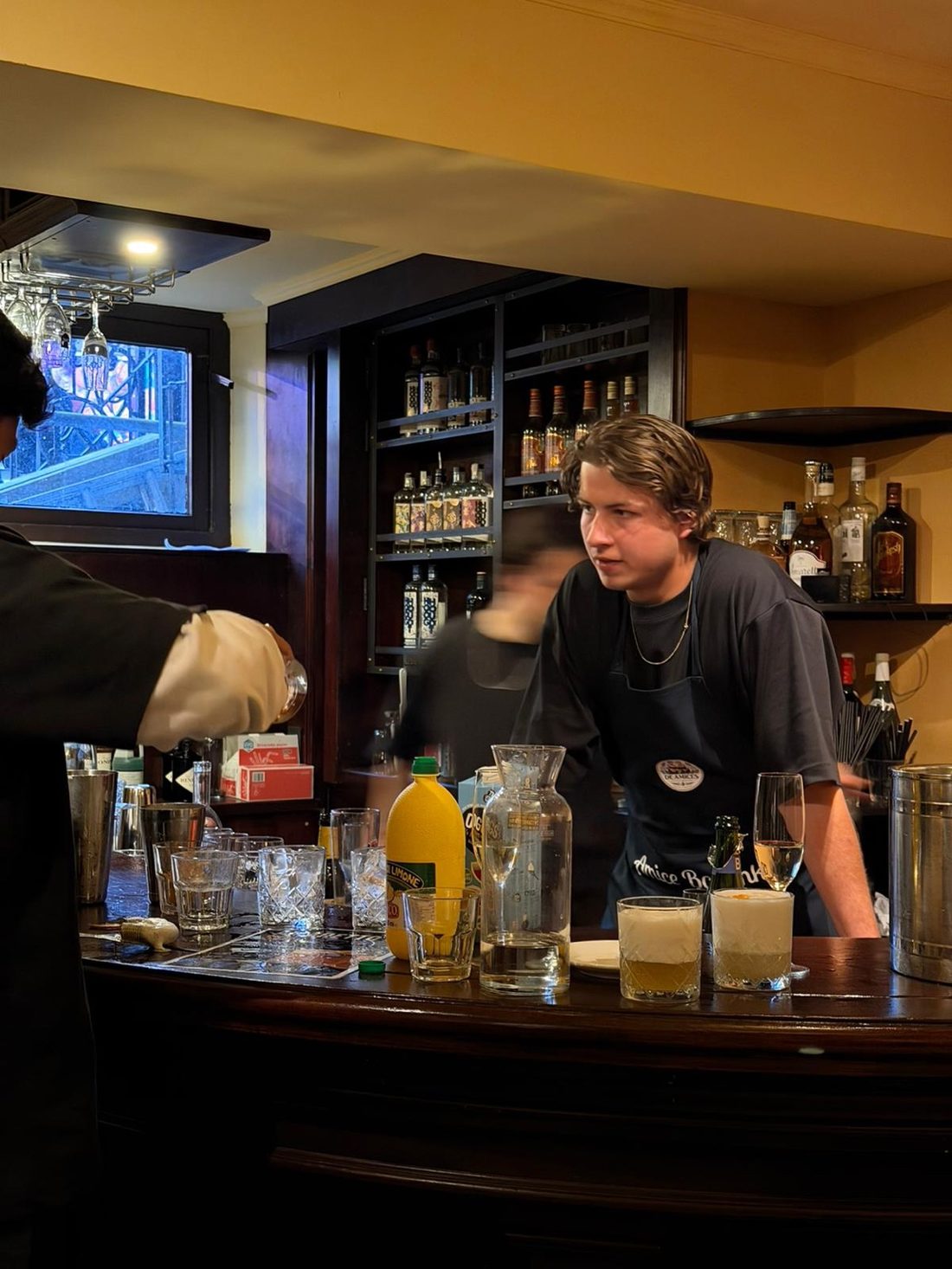 Karsten helpt een deelnemer achter de bar tijdens het shaken.